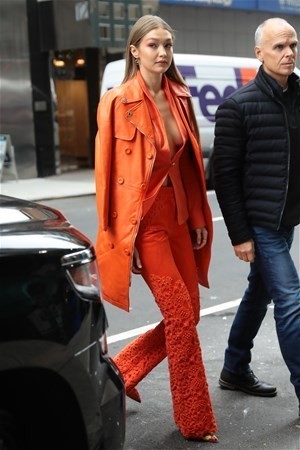 Turuncu bir takım elbise giyen güzel magazincilerin ilgi odağı oldu.